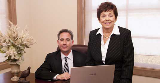 Jim Stanton and Carmen Stanton smiling at a desk in Career Employment Service, Inc.
